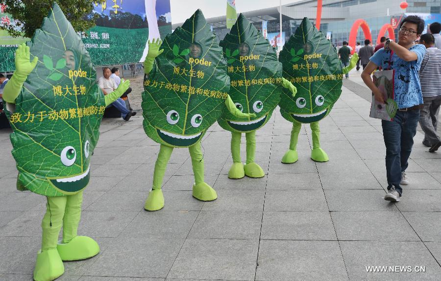 Four people wearing advertisement costumes of a disease control company are seen at the 11th (2013) China Animal Husbandry Expo in Wuhan, capital of central China's Hubei Province, May 18, 2013. The expo, which kicks off on May 18, will last until May 21. (Xinhua/Hu Weiming) 