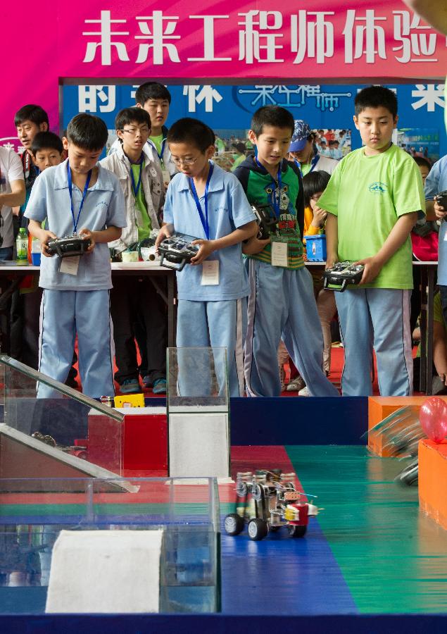 Competitors take part in a robot competition during a science exhibition in Beijing, capital of China, May 19, 2013. The exhibition is a part of the National Science and Technology Week and will last till May 25. (Xinhua/Luo Xiaoguang) 