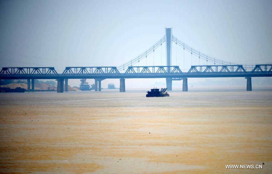 A cargo ship sails near the Ganjiang River Bridge on the Ganjiang River in Nanchang, capital of east China's Jiangxi Province, May 19, 2013. The rainfall from May 14 has pushed up the water level of the Ganjiang River, which has reached 18.95 meters by 8 a.m. on April 19, the highest level of this year. (Xinhua/Zhou Ke) 