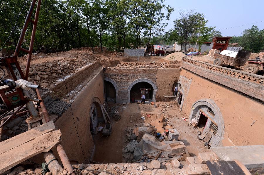 Construction workers renovate a sunken courtyard in Qucun Village of Zhangbian Township in Shaanxian County, central China's Henan Province, May 18, 2013. The sunken courtyard, a kind of traditional residential construction in west Henan, has a high value in the study of local histroy, architecture, geology and sociology. The Qucun Village has 115 sunken courtyards, most of which are under protective reconstruction. (Xinhua/Zhao Peng)