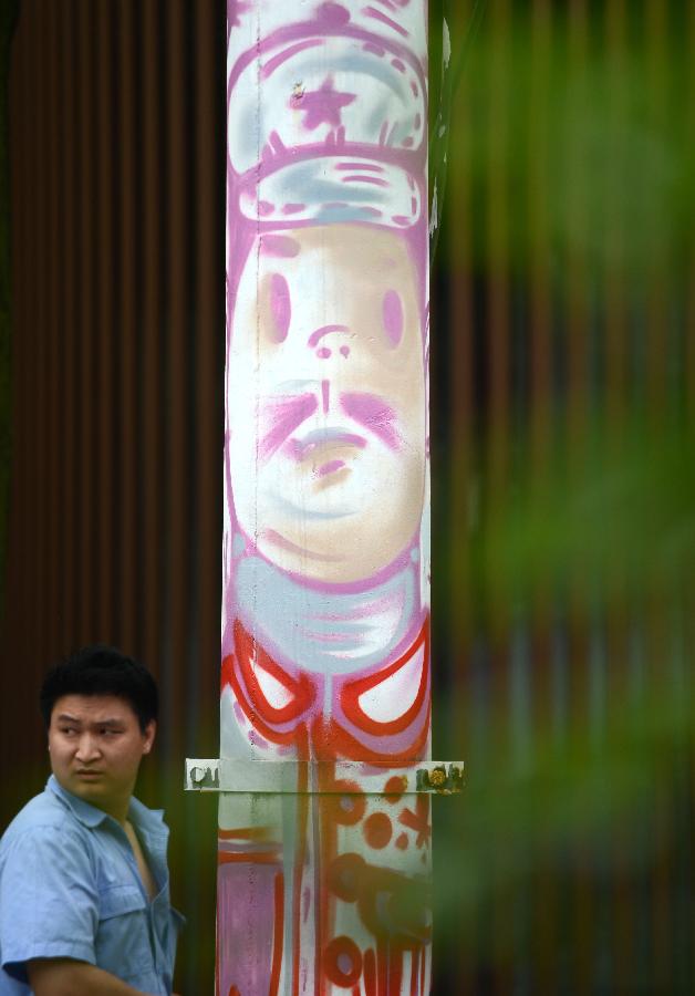 Photo taken on May 19, 2013 shows a telegraph pole decorated with graffiti in Nanchang, capital of east China's Jiangxi Province. Two graduates from the Academy of Arts and Design in Hunan University of Science and Technology designed those graffiti to express their opinions of fashion. (Xinhua/Zhou Ke) 