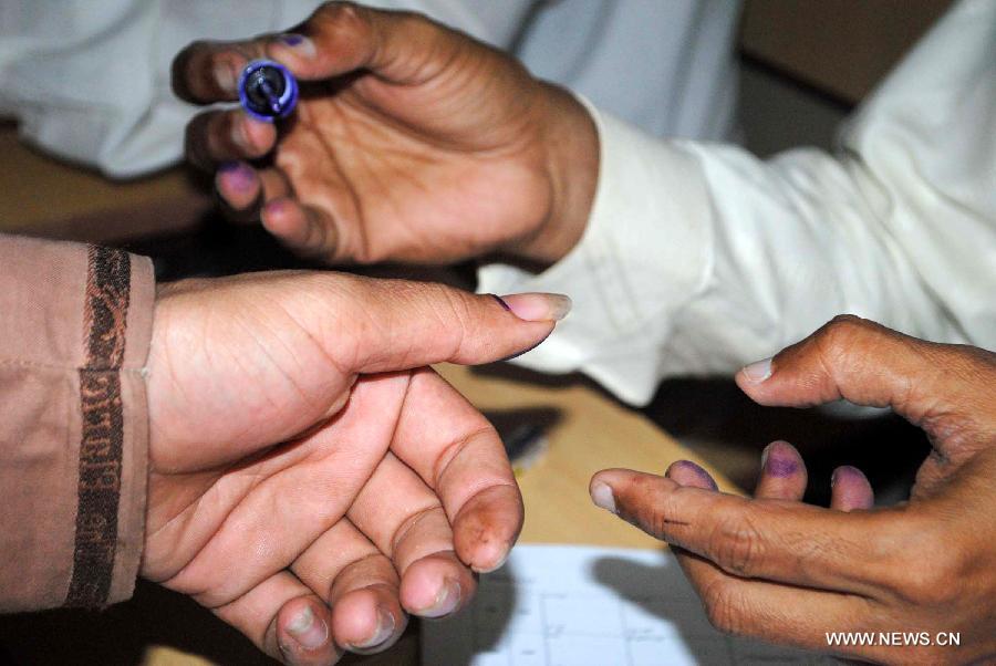 A Pakistani election presiding officer marks a voter at a polling station during the partial re-run election in southern Pakistani port city of Karachi, May 19, 2013. Re-polling on a parliamentary seat started in Pakistan's port city of Karachi Sunday morning following allegations of rigging, officials said. (Xinhua/Arshad) 