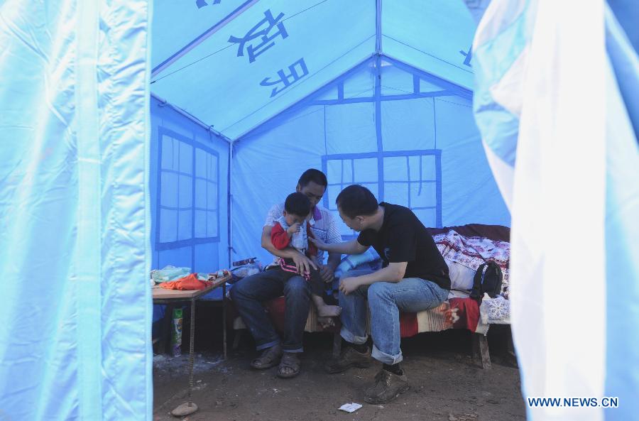 Wu Kankan (R), an engineer of the Institute of Psychology of the Chinese Academy of Sciences (CAS), offers psychological consultation service for displaced villagers in a makeshift tent in the quake-hit Lushan County, southwest China's Sichuan Province, May 15, 2013.  (Xinhua/Li Xiaoguo)