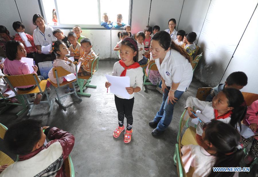 A girl is encouraged to tell a story during a psychological support course at a psychological support workstation joined by the Chinese Academy of Sciences (CAS) inside a school in the quake-hit Lushan County, southwest China's Sichuan Province, May 14, 2013.  (Xinhua/Li Xiaoguo) 