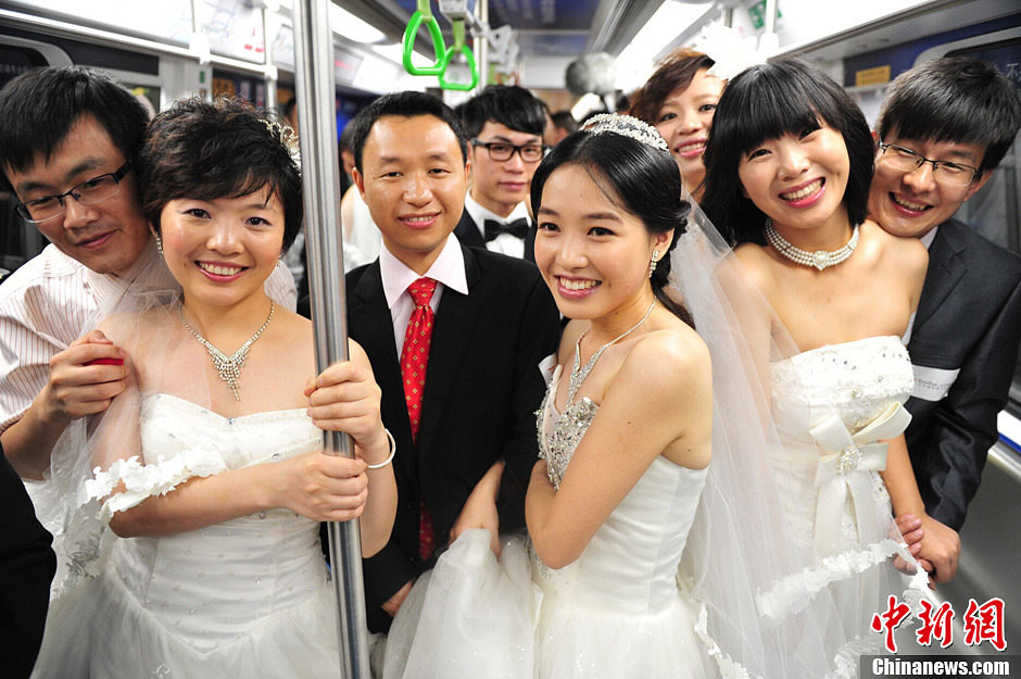 20 couples take subway to a collective wedding organized in Holiday Plaza in Shenzhen on May 19, 2013. Many citizens witness the happy moment. (CNS/Chen Wen)