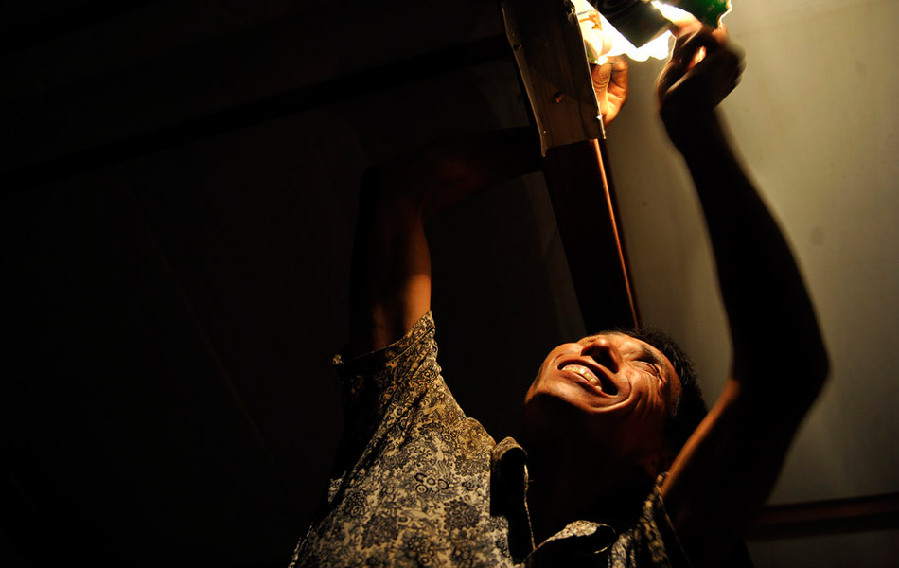 The man, 41, covers the lamp with cardboard. He and his wife live with another six male workers in the dormitory. No one complained about it because they all knew his intention clearly. (Photo/ Guangming Online)