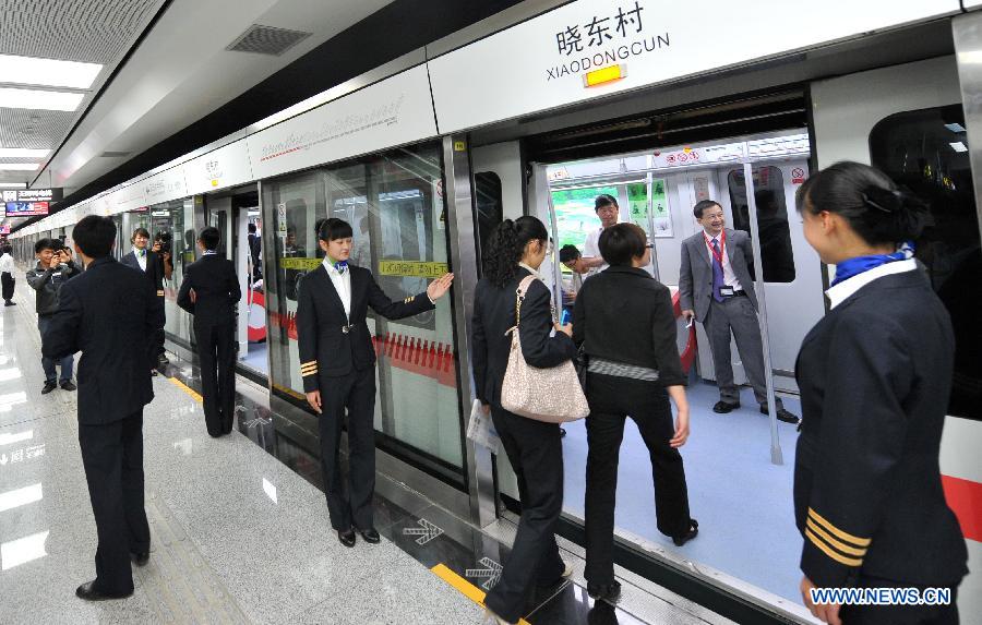 Citizens board a train at a station of the newly-opened subway line in Kunming, capital of southwest China's Yunnan Province, May 20, 2013. The southern part of the first phase of Kunming subway line 1 and line 2 opened for trial operation on Monday. It's China's first plateau subway. (Xinhua/Lin Yiguang)