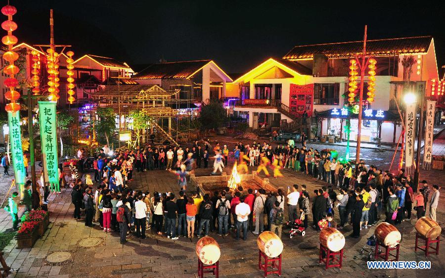 Tourists enjoy a bonfire party at the Xibu Street in Zhangjiajie, a well-known scenic spot in central China's Hunan Province, May 18, 2013. (Xinhua/Li Ga)