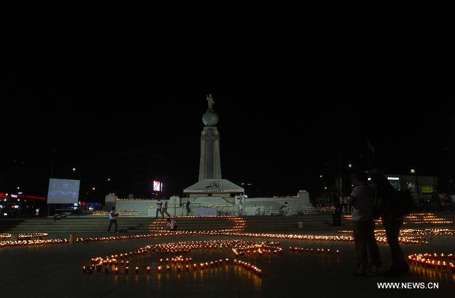 People light candles during a commemoration event for the people that died on consequence of Human Immunodeficiency Virus (HIV), organized by the Atlacatl Association Vivo Positivo, at the Salvador del Mundo Square, in San Salvador, capital of El Salvador, on May 19, 2013. A total of 4,000 candles were lit during the event. (Xinhua/Oscar Rivera)