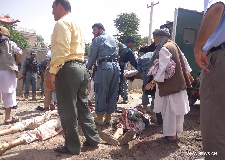 Afghan policemen gather at the site of a suicide bombing in Pul-e-Khumri city, Baghlan province, Afghanistan, May 20, 2013. 14 people, including the head of provincial council, were killed and 13 others wounded Monday morning when a suicide bombing went off near the council office building in Pul-e-Khumi, the capital city of northern Afghan province of Baghlan. (Xinhua/Sahil)