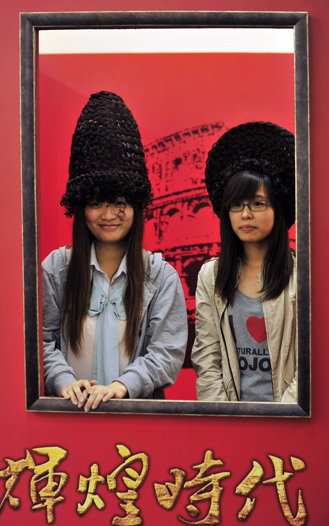 The spectators experience the hairstyle in Roman period in the exhibition of "Roman Empire" held in Taiwan on May 10, 2013. (Xinhua/Wu Jingteng)