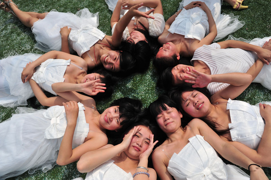 University grads from Gannan Normal University pose for photos on campus in Ganzhou of Jiangxi province on May 13, 2013. (Xinhua/Liu Nianhai)