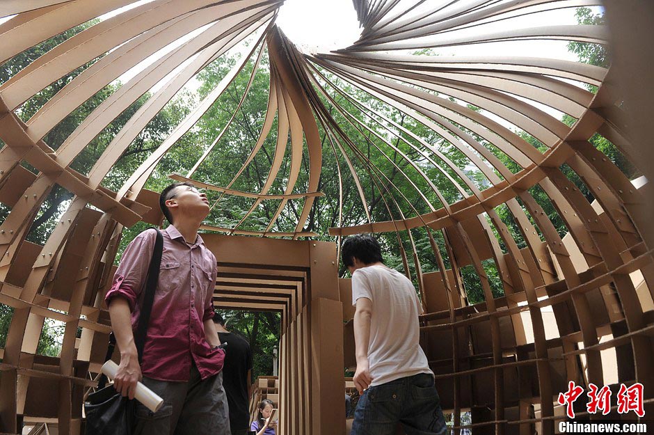 Students look a round a house made of paper boxes at Chongqing University in Southwest China's Chongqing Municipality, May 20, 2013. (CNS/Chen Chao)