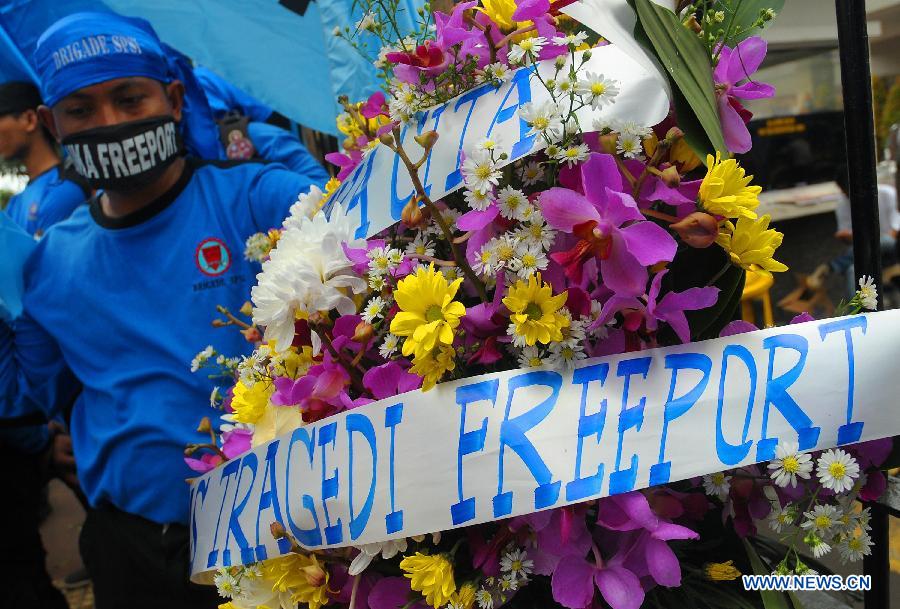 Indonesian workers carry flowers during a rally in front of the Ministry of Energy and Mineral Resources in Jakarta, Indonesia, May 21, 2013. The number of casualties in underground mine collapse at Big Gossan mine of Freeport McMorant Coppert and Gold Inc rose to 21 with 7 others remained being trapped, a statement from the firm said here Tuesday. (Xinhua/Zulkarnain)