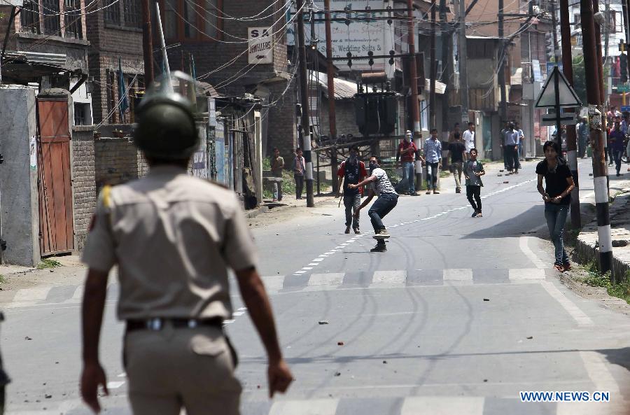 Kashmiri Muslim protestors throw stones at an Indian policeman during a strike in Srinagar, Indian-controled Kashmir, on May 21, 2013. A shutdown called by separatists to mark the anniversaries of two killed separatist leaders Mirwaiz Muhammed Farooq and Abdul Gani Lone was observed here on Tuesday. Authorities have placed moderate separatist leader Mirwaiz Umar Farooq under house arrest. (Xinhua/Javed Dar)