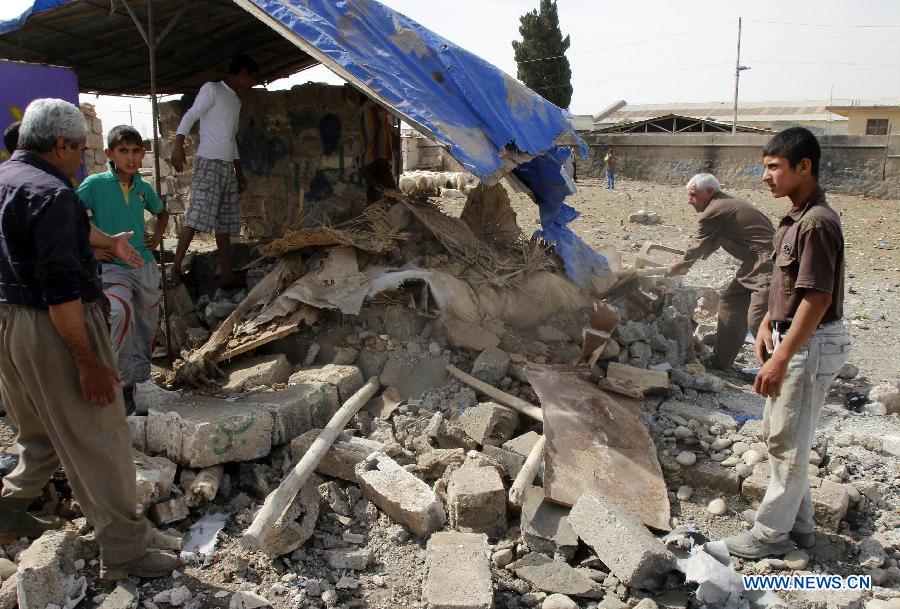 People look at the blast site in a sheep market in the Auraba district of Kirkuk, some 250 km north of Baghdad, capital of Iraq, on May 21, 2013. One civilian was killed and 25 others were injured when three bombs exploded in the sheep market on Tuesday, according to the source. At least seven people were killed and 75 others wounded in deadly bomb attacks in the war-torn Iraq on Tuesday, police said. (Xinhua/Dena Assad)