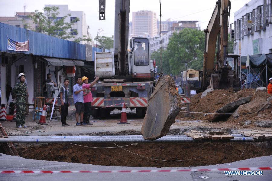 Rescuers work at the accident site where a road cave-in occurred in Huamao Industrial Park in Shenzhen, south China's Guangdong Province, May 21, 2013. The accident occurred around 9:19 p.m. (1319 GMT) on May 20. As of 4:30 p.m. (0830 GMT) Tuesday, 5 people were killed and another one injured as the cave-in led to a pit measuring three to four meters deep. Search and rescue efforts are under way. (Xinhua/Liang Xu) 