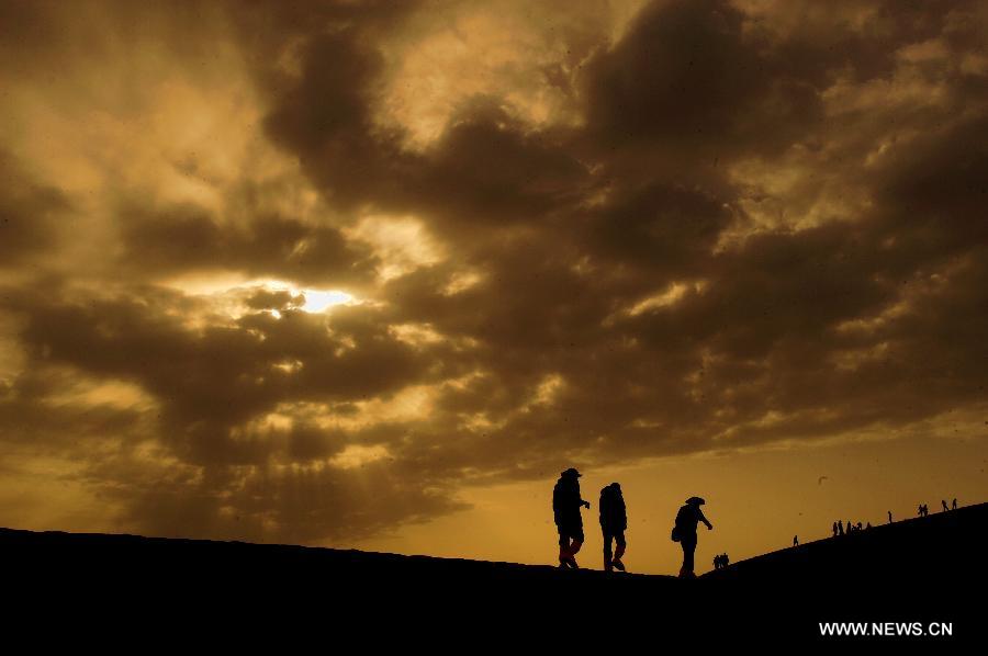 Tourists visit the scenic spot of the Mingsha Mountain and Crescent Spring in Dunhuang City, northwest China's Gansu Province, May 21, 2013. Dunhuang has received about 749,200 tourists in the first four months of 2013, increasing 58.63 percent year on year. (Xinhua/Nie Jianjiang)