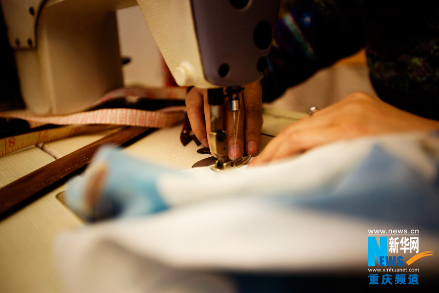 Shi Yuhong makes cheongsam in Chongqing on March 29, 2013. (Photo/Xinhua)