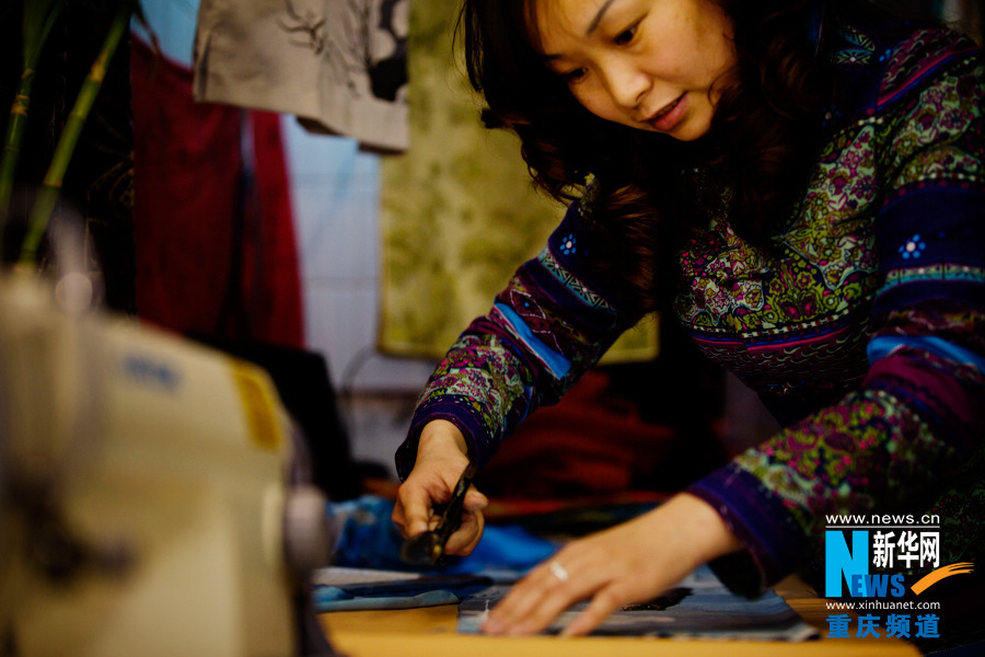 Shi Yuhong, manager of a cheongsam shop in Chongqing, makes cheongsam on March 29, 2013. Generally, a simple summer cheongsam will take her two or three days to complete. (Photo/Xinhua)