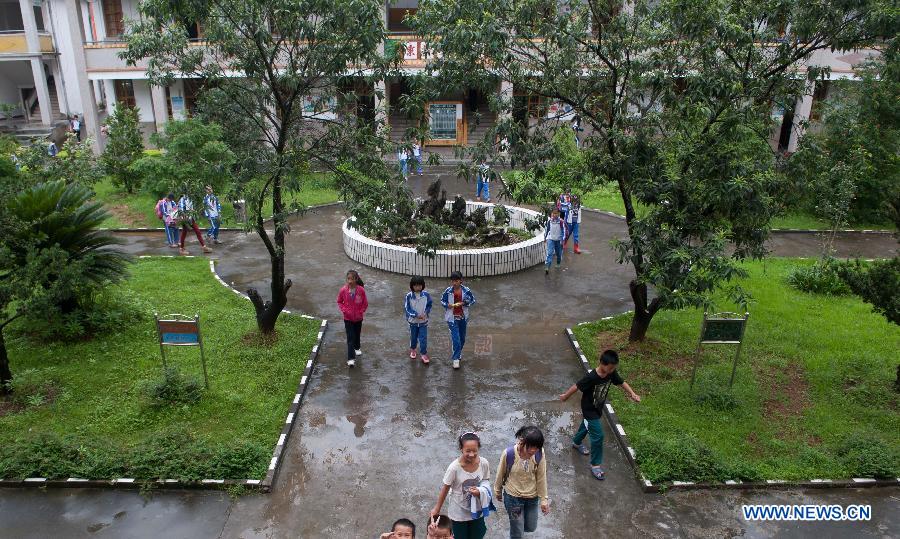 Students of the Guangfu Middle School go home after class in Jiaoling County, south China's Guangdong Province, May 23, 2013. The Guangfu Middle School, which was flooded in the rainstorm hitting Meizhou City on May 19, has resumed classes. (Xinhua/Mao Siqian) 