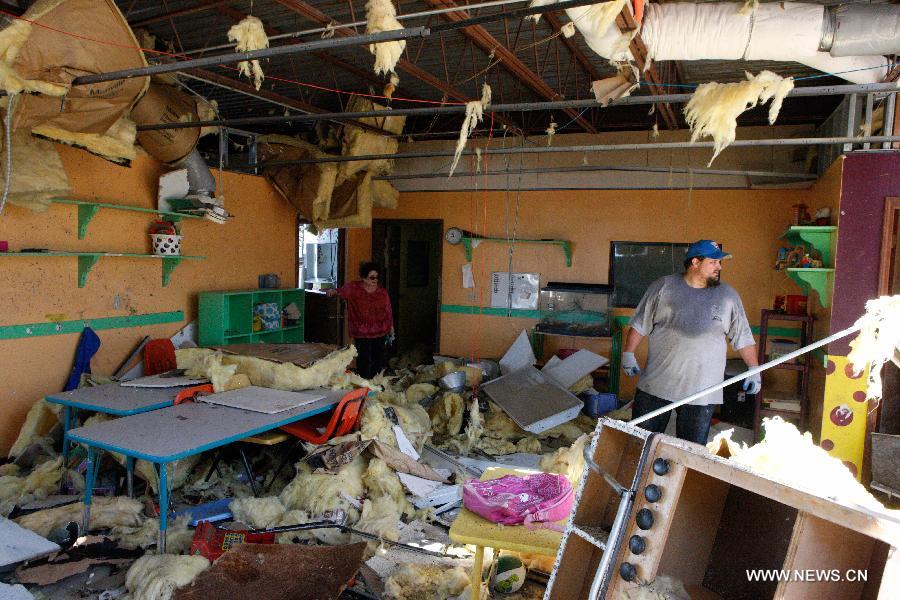 Lawrence family clean up a tornado-destroyed preschool in Moore, Oklahoma, the United States, May 22, 2013. Twenty-four people were killed and 237 others injured when a massive tornado blasted the southern suburbs of Oklahoma City on Monday. (Xinhua/Song Qiong) 