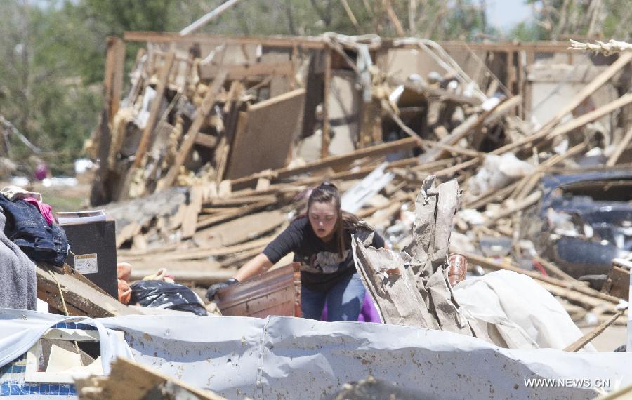 A woman cleans up in a tornado-destroyed neighborhood in Moore, Oklahoma, the United States, May 22, 2013. Twenty-four people were killed and 237 others injured when a massive tornado blasted the southern suburbs of Oklahoma City on Monday, state officials said Tuesday. (Xinhua/Marcus DiPaola) 