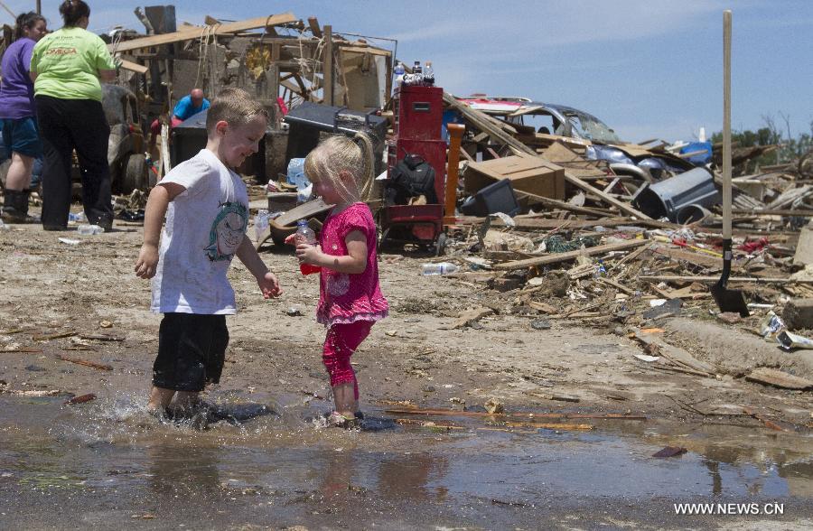 Children play in a tornado-destroyed neighborhood in Moore, Oklahoma, the United States, May 22, 2013. Twenty-four people were killed and 237 others injured when a massive tornado blasted the southern suburbs of Oklahoma City on Monday, state officials said Tuesday. (Xinhua/Marcus DiPaola) 