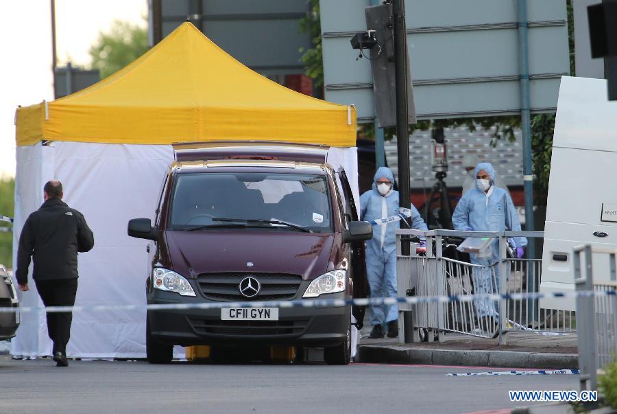 Police forensic officers investigate a crime scene in Woolwich, southeast London May 22, 2013. A man was found dead at the scene and two other men were taken to the hospital in London neighbourhood of Woolwich on Wednesday. (Xinhua/Yin Gang) 