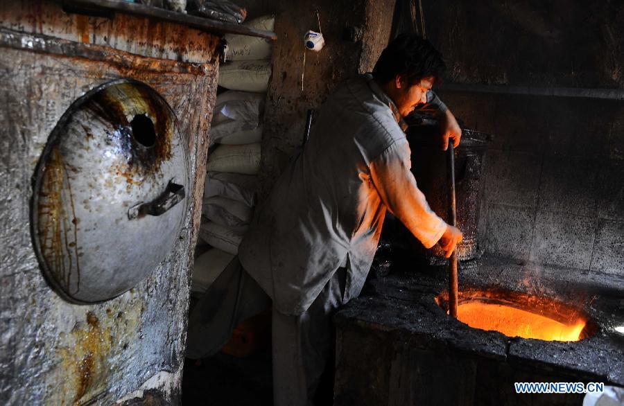 An Afghan man works at a traditional sweet factory in Herat province, western Afghanistan, on May 22, 2013. (Xinhua/Sardar)