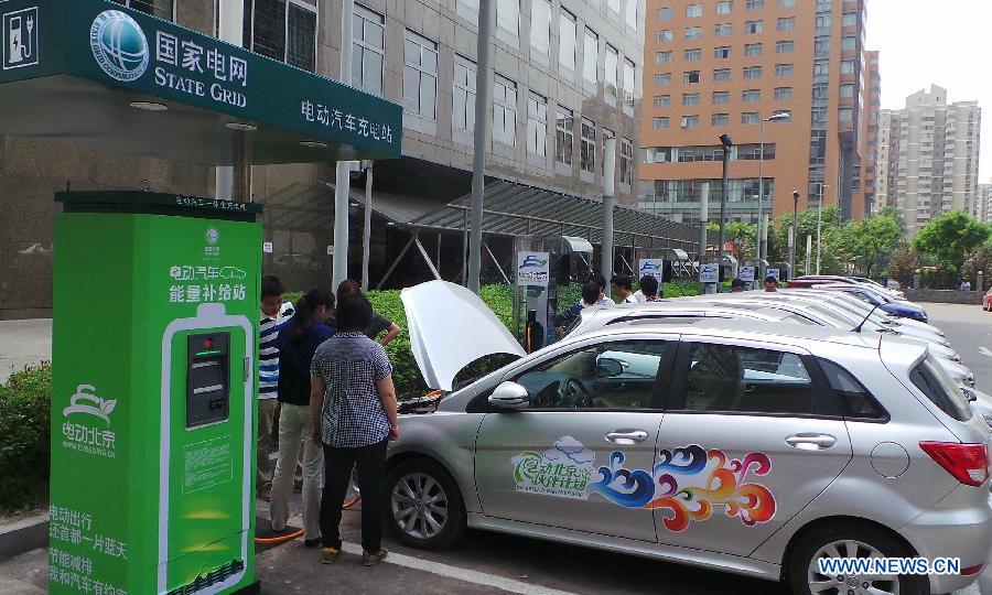 Electric cars get charged at a rental station in the Tsinghua University Science Park in Beijing, capital of China, May 23, 2013. Fifteen electric cars can be rented at the station. There will be 2,000 electric cars for renting in Beijing by the end of this year. (Xinhua/Li Xin)