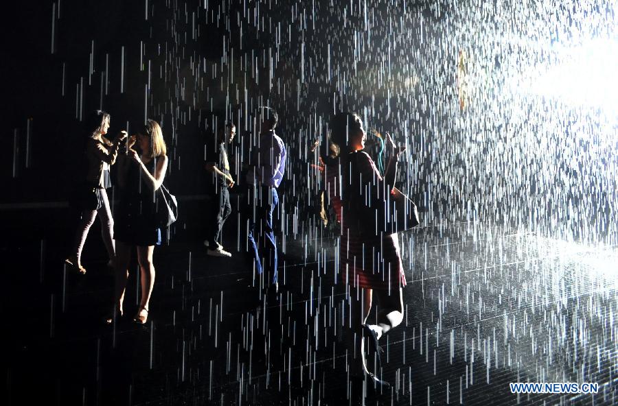 People experience the "Rain Room" art installation by Random International at the Museum of Modern Art in New York, the United States, May 22, 2013. A field of falling water that pauses wherever a human body is detected, "Rain Room" offers visitors the experience of controlling the rain. (Xinhua/Wang Lei) 