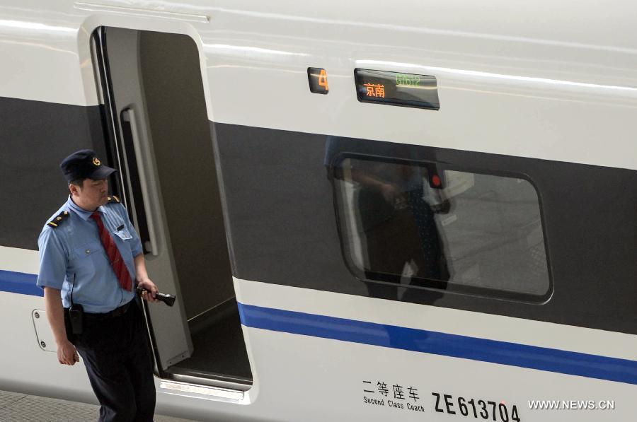 An attendant checks a high-speed train from Nanjing at the Hangzhou East Station in Hangzhou, capital of east China's Zhejiang Province, May 24, 2013. High-speed rail lines from Nanjing to Hangzhou and Hangzhou to Ningbo began a month-long trial operations on Friday. (Xinhua/Han Chuanhao) 