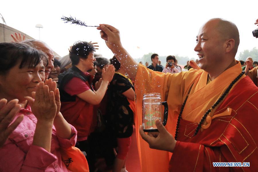 A master sprays water to pray for Buddhist believers at the China (Nanjing) International Buddhist Cultural Items & Crafts Fair in Nanjing, capital of east China's Jiangsu Province, May 23, 2013. (Xinhua/Han Hua)