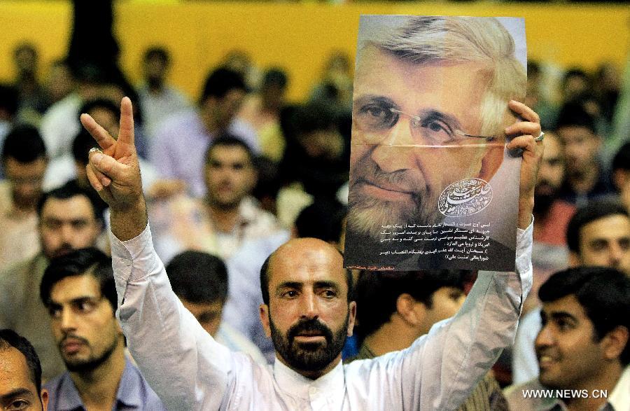 A man holds up a poster of Iran's chief nuclear negotiator and presidential candidate Saeed Jalili during a campaign rally in downtown Tehran, Iran, on May 24, 2013. Iran's Guardian Council of Constitution announced the names of eight eligible candidates for the upcoming presidential election while barring two major political figures from running for presidency. (Xinhua/Ahmad Halabisaz) 