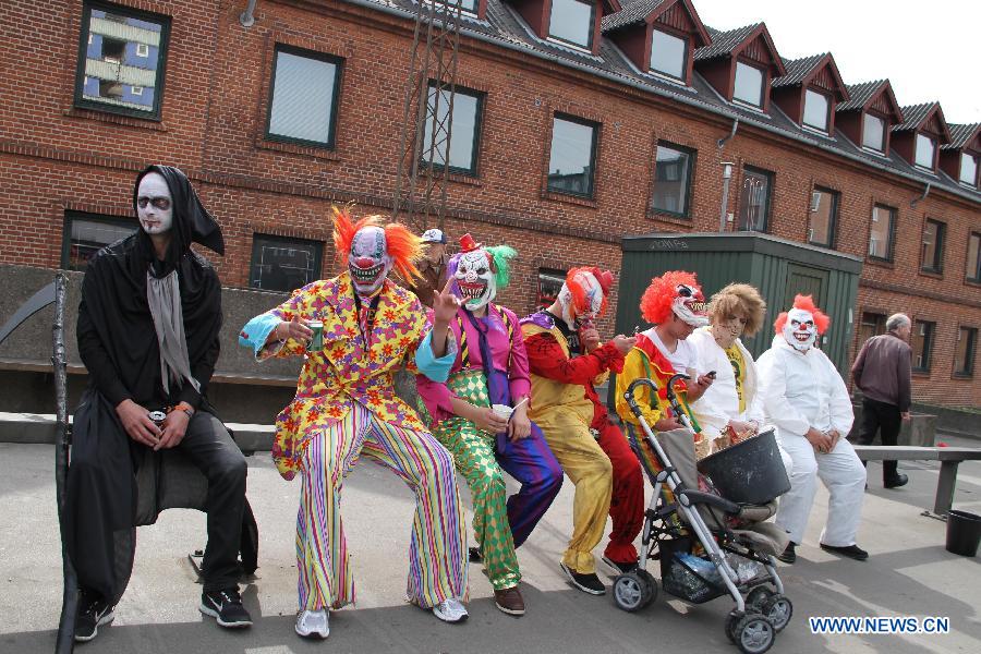 Revellers joining in a carnival parade rest by a street during the Aalborg Carnival in Aalborg, on May 25, 2013. The nine-day festive event started on May 17. (Xinhua/Yang Jingzhong)