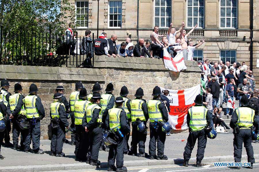 Police stand guard while protesters attend the demonstration against the killing of the British soldier in Newcastle, May 25, 2013. Nearly 2,000 people from around Britain took to the street on Saturday afternoon in Newcastle in northern England. (Xinhua/Yin Gang) 