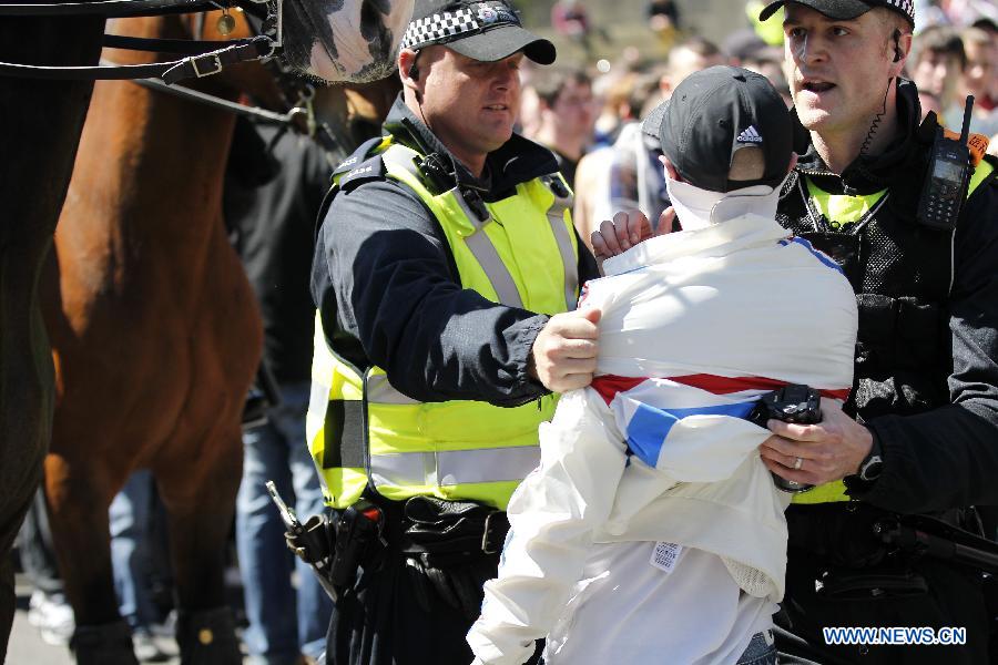 Police stand guard while protesters attend the demonstration against the killing of the British soldier in Newcastle, May 25, 2013. Nearly 2,000 people from around Britain took to the street on Saturday afternoon in Newcastle in northern England. (Xinhua/Yin Gang) 