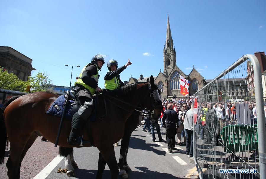 Police stand guard while protesters attend the demonstration against the killing of the British soldier in Newcastle, May 25, 2013. Nearly 2,000 people from around Britain took to the street on Saturday afternoon in Newcastle in northern England. (Xinhua/Yin Gang) 