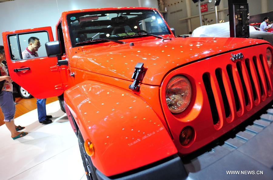 Local residents experience a car displayed at an auto show in Wuhan, capital of central China's Hubei Province, May 26, 2013. The four-day auto show, which kicked off on Saturday, attracted more than 70 auto brands. (Xinhua/Xiao Yijiu) 