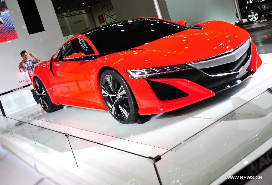 A man takes pictures of a car displayed at an auto show in Wuhan, capital of central China's Hubei Province, May 26, 2013. The four-day auto show, which kicked off on Saturday, attracted more than 70 auto brands. (Xinhua/Xiao Yijiu) 