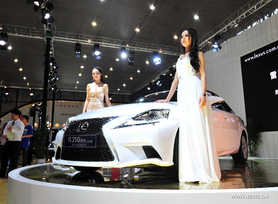 Models present a car displayed at an auto show in Wuhan, capital of central China's Hubei Province, May 26, 2013. The four-day auto show, which kicked off on Saturday, attracted more than 70 auto brands. (Xinhua/Xiao Yijiu) 