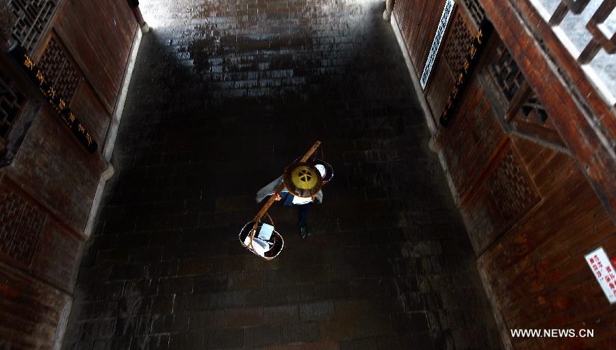 A vendor walks on a veranda bridge in Xuan'en County, central China's Hubei Province, May 25, 2013. Veranda bridge is a typical architecture of China's Dong ethnic group in south China. (Xinhua/Song Wen)  