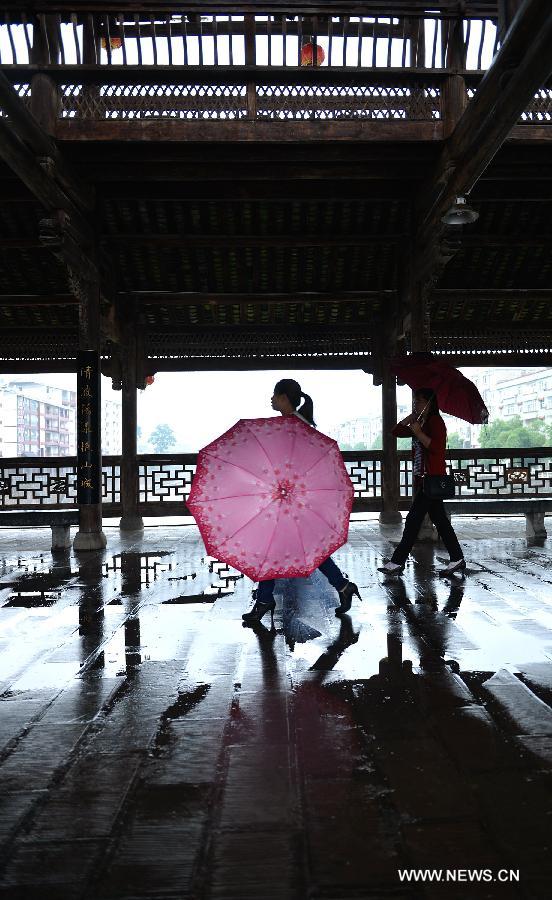 Pedestrians walk on a veranda bridge in Xuan'en County, central China's Hubei Province, May 25, 2013. Veranda bridge is a typical architecture of China's Dong ethnic group in south China. (Xinhua/Song Wen)  