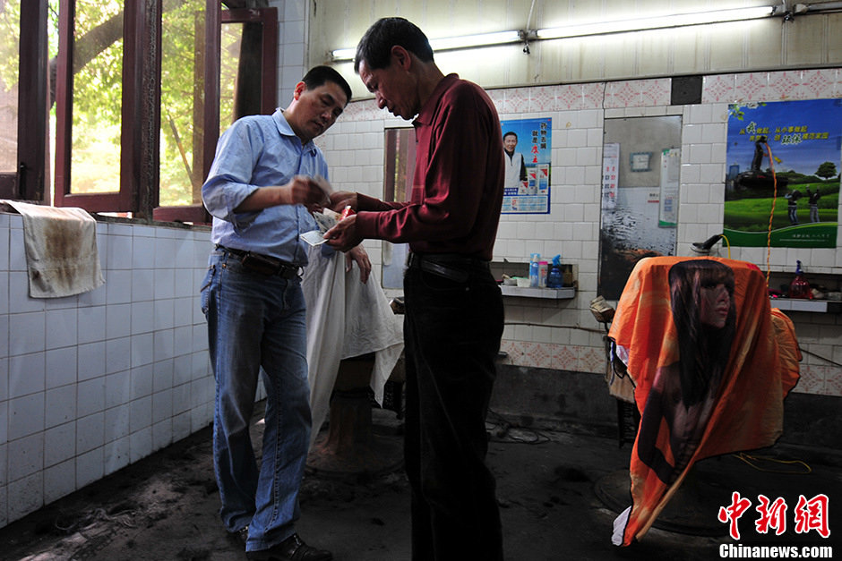 A client pays 8 yuan(1.1 US dollar) for a crew cut. Clients couldn’t find the same fair price in other barbershops.(Photo/Chinanews)