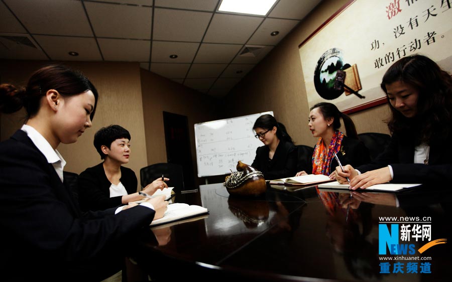 He Jinzhu and staff members discuss intraday work arrangement at meeting in early morning of every working day. (Photo/Xinhua)