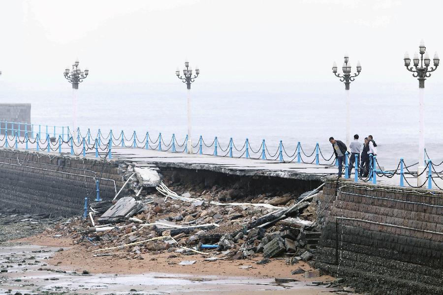 People check the collapsed part of Zhanqiao Bridge in Qingdao, east China's Shandong Province, May 27, 2013. Part of the bridge was hit and destroyed by thunderstorms and waves on early Monday morning. Built in 1892, the Zhanqiao Bridge is a landmark for Qingdao. (Xinhua/Huang Jiexian) 