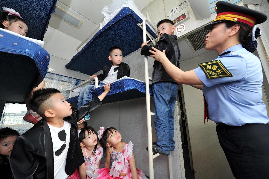 An attendant introduces the way to use the ladder beside the bunks to children on a train from Yinchuan, capital of northwest China's Ningxia Hui Autonomous Region, to Beijing, capital of China, May 27, 2013. Children from the kindergarten of Ningxia University visited the train and held a performance to celebrate the upcoming Children's Day. (Xinhua/Peng Zhaozhi) 