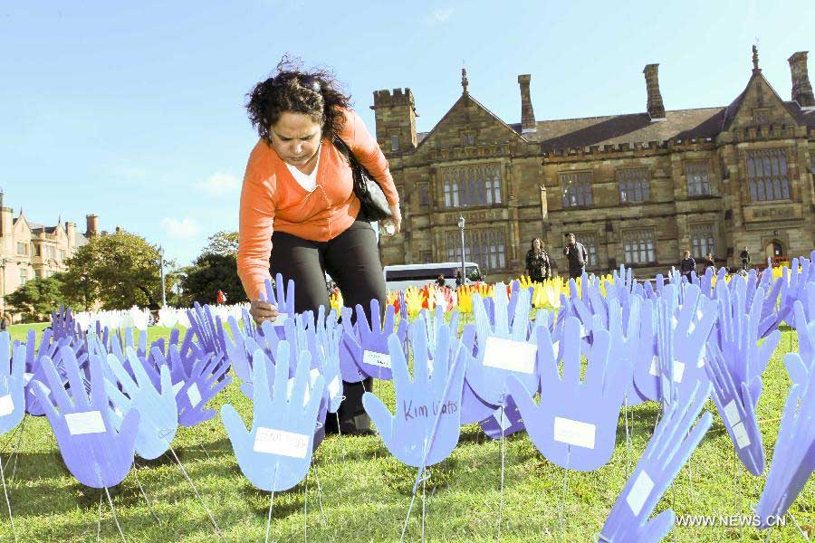 A woman plants a plastic hand in the large art work of "The Sea of Hands" during the Reconciliation Week 2013 in the University of Sydney, Australia, on May 27, 2013. The first "Sea of Hands" was held on Oct. 12, 1997, in Australia's capital of Canberra. (Xinhua/Jin Linpeng) 