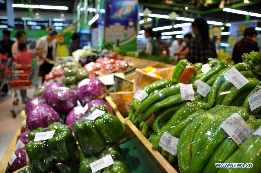 Citizens select vegetables at a supermarket in Xingtai, north China's Hebei Province, May 27, 2013. Prices of edible farm produce in 36 major Chinese cities declined for five consecutive weeks, the Ministry of Commerce said on May 27. The average wholesale prices for 18 vegetables on the monitored list dropped by 5.2 percent week on week and declined by 21.9 percent over the price of five weeks ago. (Xinhua/Zhu Xudong)
